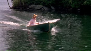 Movie still from “On Golden Pond” (1981), directed by Mark Rydell – An older man in a straw hat rides in a boat on a lake; Wide shot, High angle