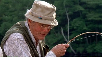 Movie still from “On Golden Pond” (1981), directed by Mark Rydell – An older man holding a fishing pole in his hands; Close Up shot, Low angle