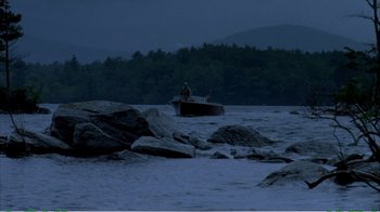 Movie still from “On Golden Pond” (1981), directed by Mark Rydell – A person in a boat on a body of water at night; Extreme Wide shot, High angle
