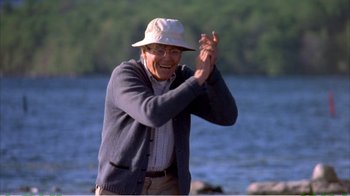 Movie still from “On Golden Pond” (1981), directed by Mark Rydell – An older man wearing a hat and clapping hands; Medium shot, Low angle