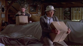 Movie still from “On Golden Pond” (1981), directed by Mark Rydell – Two people sitting on a bed holding boxes; Medium shot, Low angle