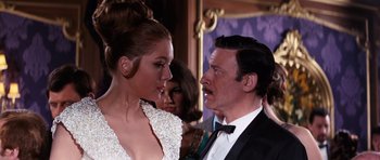 Movie still from “On Her Majesty's Secret Service” (1969), directed by Peter R. Hunt – A man and a woman in formal wear looking at one another; Medium shot, Low angle