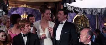 Movie still from “On Her Majesty's Secret Service” (1969), directed by Peter R. Hunt – A man and a woman in formal wear standing next to each other; Medium shot, Low angle