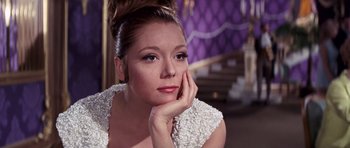 Movie still from “On Her Majesty's Secret Service” (1969), directed by Peter R. Hunt – A beautiful woman sitting down with her head resting on her hand; Close Up shot, Low angle