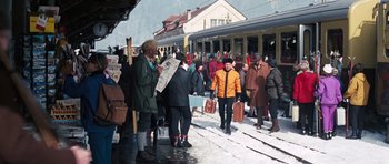 Movie still from “On Her Majesty's Secret Service” (1969), directed by Peter R. Hunt – A group of people standing on a train platform next to a train; Wide shot, High angle