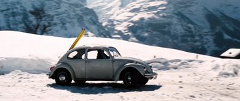 Movie still from “On Her Majesty's Secret Service” (1969), directed by Peter R. Hunt – An old car with skis strapped to the back of the car; Wide shot, Low angle