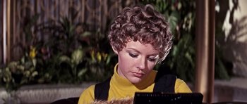 Movie still from “On Her Majesty's Secret Service” (1969), directed by Peter R. Hunt – A woman with curly brown hair wearing a yellow sweater; Close Up shot, Low angle