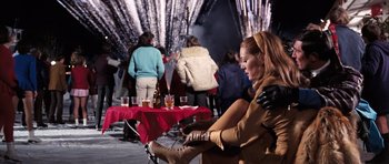 Movie still from “On Her Majesty's Secret Service” (1969), directed by Peter R. Hunt – A group of people sitting around a table with drinks on it; Medium shot, Over the shoulder angle