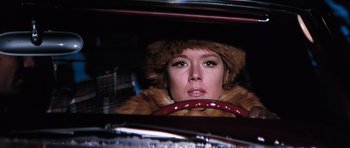 Movie still from “On Her Majesty's Secret Service” (1969), directed by Peter R. Hunt – A woman in a fur hat driving a car; Close Up shot, Low angle
