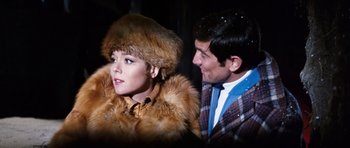 Movie still from “On Her Majesty's Secret Service” (1969), directed by Peter R. Hunt – A man and a woman wearing fur coats and hats; Close Up shot, Over the shoulder angle