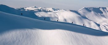 Movie still from “On Her Majesty's Secret Service” (1969), directed by Peter R. Hunt – A group of skiers skiing down a snowy slope; Extreme Wide shot, Low angle