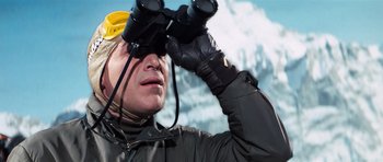 Movie still from “On Her Majesty's Secret Service” (1969), directed by Peter R. Hunt – A man looking through a pair of binoculars; Close Up shot, Low angle