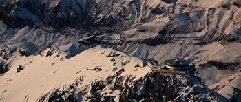 Movie still from “On Her Majesty's Secret Service” (1969), directed by Peter R. Hunt – A helicopter is flying over a snowy mountain; Extreme Wide shot, High angle