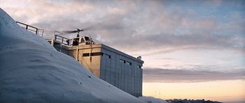 Movie still from “On Her Majesty's Secret Service” (1969), directed by Peter R. Hunt – A helicopter flying over a building on top of a snow covered slope; Extreme Wide shot, Low angle