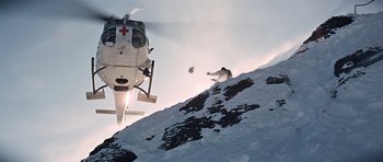 Movie still from “On Her Majesty's Secret Service” (1969), directed by Peter R. Hunt – A helicopter flying over a person skiing down a mountain; Extreme Wide shot, Low angle