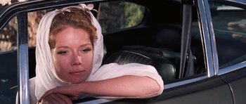Movie still from “On Her Majesty's Secret Service” (1969), directed by Peter R. Hunt – A woman sitting in the passenger seat of a car; Close Up shot, Low angle