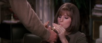 Movie still from “On a Clear Day You Can See Forever” (1970), directed by Vincente Minnelli – A woman eating a piece of food from a man's hand; Close Up shot, Over the shoulder angle