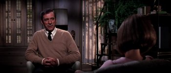 Movie still from “On a Clear Day You Can See Forever” (1970), directed by Vincente Minnelli – A man sitting in front of a woman in a living room; Medium shot, Over the shoulder angle