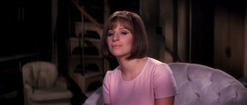Movie still from “On a Clear Day You Can See Forever” (1970), directed by Vincente Minnelli – A woman in a pink shirt sitting in a chair; Close Up shot, Over the shoulder angle