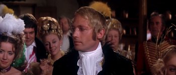 Movie still from “On a Clear Day You Can See Forever” (1970), directed by Vincente Minnelli – A person wearing a suit and feather headdress; Close Up shot, Over the shoulder angle