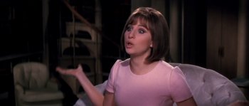 Movie still from “On a Clear Day You Can See Forever” (1970), directed by Vincente Minnelli – A woman in a pink shirt is looking surprised; Close Up shot, Over the shoulder angle