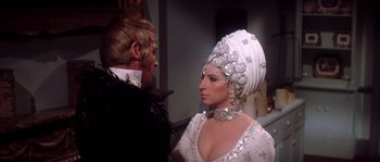 Movie still from “On a Clear Day You Can See Forever” (1970), directed by Vincente Minnelli – A man standing next to a woman in a white dress; Medium shot, Over the shoulder angle