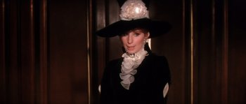 Movie still from “On a Clear Day You Can See Forever” (1970), directed by Vincente Minnelli – A woman wearing a black hat and a black dress; Close Up shot, Over the shoulder angle