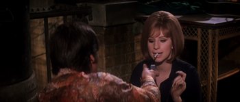 Movie still from “On a Clear Day You Can See Forever” (1970), directed by Vincente Minnelli – A woman is putting lipstick on a man's face; Medium shot, Over the shoulder angle