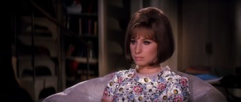 Movie still from “On a Clear Day You Can See Forever” (1970), directed by Vincente Minnelli – A woman sitting in a chair looking at the camera; Close Up shot, High angle