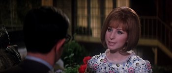 Movie still from “On a Clear Day You Can See Forever” (1970), directed by Vincente Minnelli – A man and a woman talking to each other in front of flowers; Close Up shot, Over the shoulder angle