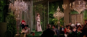 Movie still from “On a Clear Day You Can See Forever” (1970), directed by Vincente Minnelli – A woman in a white dress standing on a stage; Wide shot, Over the shoulder angle