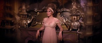 Movie still from “On a Clear Day You Can See Forever” (1970), directed by Vincente Minnelli – A woman in a pink dress standing in front of a mirror; Medium shot, High angle