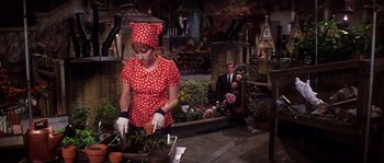 Movie still from “On a Clear Day You Can See Forever” (1970), directed by Vincente Minnelli – A woman in a red polka dot dress and a man in a black suit; Medium shot, High angle
