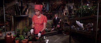 Movie still from “On a Clear Day You Can See Forever” (1970), directed by Vincente Minnelli – A woman in a red polka dot dress and a man in a black suit; Medium shot, Over the shoulder angle