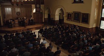 Movie still from “On the Basis of Sex” (2018), directed by Mimi Leder – A group of people sitting in front of an audience in a room; Extreme Wide shot, High angle