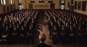 Movie still from “On the Basis of Sex” (2018), directed by Mimi Leder – A large group of men in suits sitting in a room; Extreme Wide shot, High angle