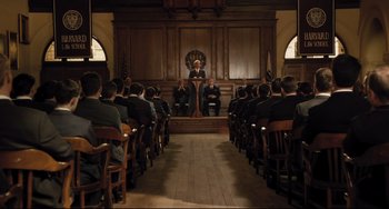 Movie still from “On the Basis of Sex” (2018), directed by Mimi Leder – A group of people sitting in front of a podium; Wide shot, High angle
