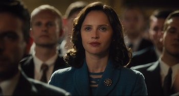 Movie still from “On the Basis of Sex” (2018), directed by Mimi Leder – A woman in a blue suit and a man in a brown suit; Close Up shot, Over the shoulder angle
