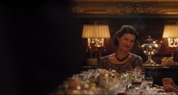 Movie still from “On the Basis of Sex” (2018), directed by Mimi Leder – A woman sitting at a dinner table with a lot of glasses; Medium shot, Over the shoulder angle