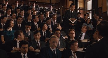 Movie still from “On the Basis of Sex” (2018), directed by Mimi Leder – A group of men in suits and ties sitting in a room; Wide shot, High angle