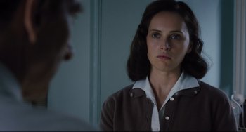 Movie still from “On the Basis of Sex” (2018), directed by Mimi Leder – A woman looking into a mirror while standing up; Close Up shot, Over the shoulder angle
