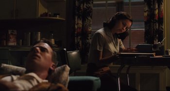 Movie still from “On the Basis of Sex” (2018), directed by Mimi Leder – A woman sitting at a table in a living room; Medium shot, Low angle
