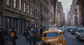 Movie still from “On the Basis of Sex” (2018), directed by Mimi Leder – A yellow taxi cab parked on the side of the street; Extreme Wide shot, High angle