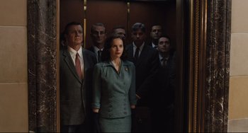 Movie still from “On the Basis of Sex” (2018), directed by Mimi Leder – A group of men and a woman standing in an elevator; Medium shot, Low angle