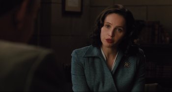 Movie still from “On the Basis of Sex” (2018), directed by Mimi Leder – A woman in a blue jacket sitting in front of a wall; Close Up shot, Over the shoulder angle