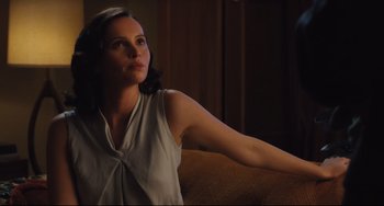 Movie still from “On the Basis of Sex” (2018), directed by Mimi Leder – A woman sitting on top of a couch with her arm outstreched; Medium shot, Low angle