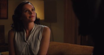 Movie still from “On the Basis of Sex” (2018), directed by Mimi Leder – A woman sitting on a couch in a living room; Close Up shot, Over the shoulder angle