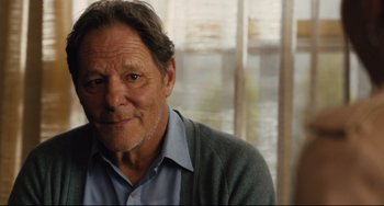 Movie still from “On the Basis of Sex” (2018), directed by Mimi Leder – An older man wearing a blue shirt and a gray cardigan; Close Up shot, Over the shoulder angle