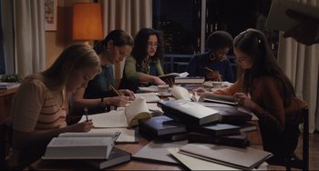 Movie still from “On the Basis of Sex” (2018), directed by Mimi Leder – A group of people sitting at a table writing on papers; Medium shot, High angle