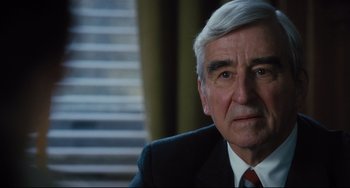 Movie still from “On the Basis of Sex” (2018), directed by Mimi Leder – An older man wearing a suit and a red neck tie; Close Up shot, Over the shoulder angle
